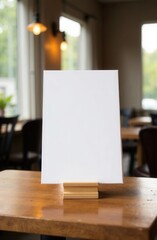 A clean, white sign is resting on a wooden table inside a restaurant
