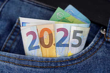 cash in the trouser pocket shows the year 2025, euro banknotes in blue jeans symbolize wealth or tax changes in the new year in europe