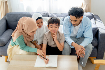 Asian little boy express thinking action during write puzzle game for playing with his older sister and joy with the family at home.