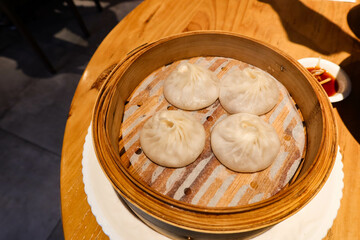 close up of shanghai Chinese steamed soup meat dumpling dim sum in a bamboo steamer 