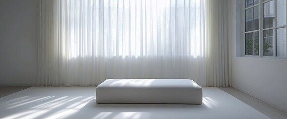 Minimalist room with ottoman, sheer curtains, and sunlight.