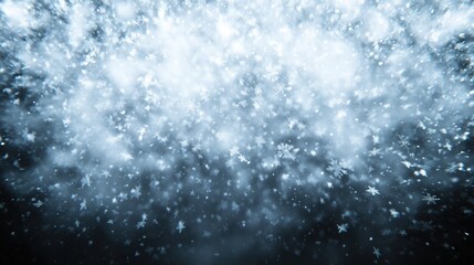 Snowflakes falling against a blurred blue background. winter-themed visuals and seasonal concepts