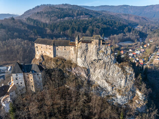 Obraz premium Aerial view of the Orava castle at winter, Slovakia. Medieval Oravsky Hrad castle on high and steep cliffs by the Orava River.