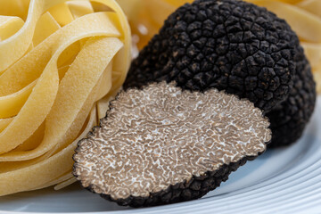 Italian food, tagliatelle pasta with  mushrooms, fresh black summer truffle mushroom for making...