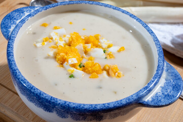 Spring season, homemade soup from raw white asparagus and cooked eggs, new harvest of Dutch, German white asparagus