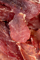 dried dried meat from meat tenderloin with spices and salt on black slate