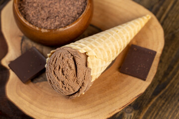 chocolate ice cream in a cone on a board