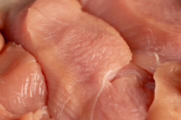 a lot of a piece of fresh chicken meat in close-up lies on paper