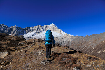 Backpacking woman hiking on high altitude mountain top