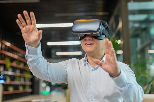 Mature business man programmer software developer using headset app making a presentation. Watching virtual reality 3D 360 video. Middle-aged guy manager in shirt in VR goggles working at office lobby