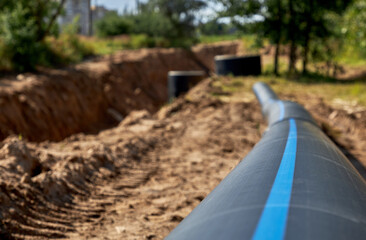 Close-up of a large industrial plastic polypropylene water pipe at a construction site for laying water pipes, construction and reconstruction of buildings and cottages.