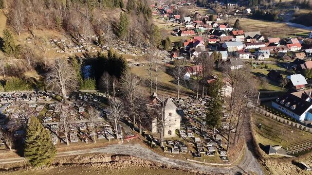 Aerial Drone View of an Old Church in the Middle of a Cemetery in Rural Landscape, Rotating View