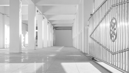 Stainless steel sliding door with light and shadow on tile floor of corridor inside of white temple building, Black and white style and perspective side view