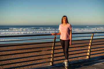 Young woman with inline skates enjoying the sunset on the beach © EDER