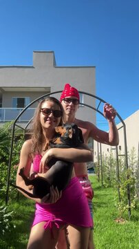 casal brinca com cachorros em area externa 
