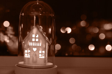 Mocha Mousse toning, color of the year 2025. Fairy Christmas house with candlelight inside,...