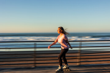 Woman enjoying inline skating by the sea at sunset © EDER