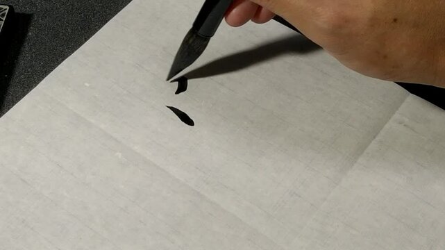Writing the calligraphy character "Quick" in the "Slender Gold" style on white paper.