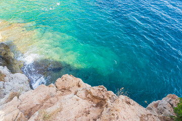 French Riviera: a breathtaking view of the turquoise waters of the Mediterranean Sea washing the rocky shore.