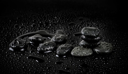 Oval stones with water drops on black background