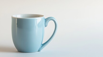 A cute, pastel blue ceramic mug with a heart-shaped handle, placed on a white background with room for copy
