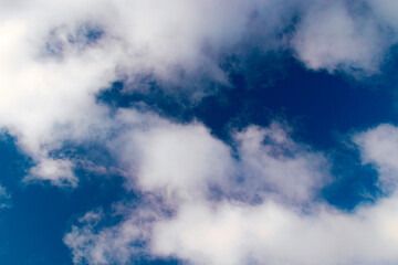 A few light cumulus clouds in a clear blue sky. summer bright image of the sky.