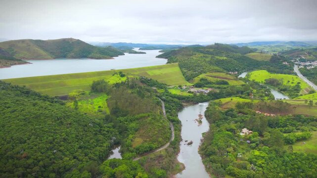 aerial view of a river and a reservoir in the countryside of Sao Paulo state in Paraibuna city with mountains at distance in a cloud day