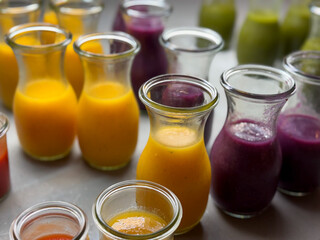 Fresh smoothie drinks made of fresh fruits, berries and vegetables in glass jars in buffet restaurant