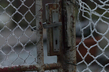 Old Door handle on an outdoor entrance door at winter. The sturdy design and materials emphasize functionality and durability, highlighting the blend of practicality and style in urban architecture.