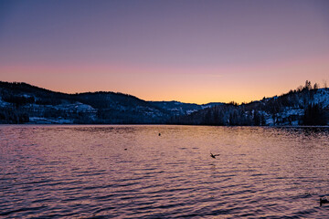 Sunset at Titisee during the winter time with snow covered ground and calm water