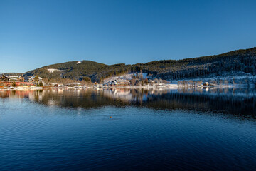 Fototapeta premium The Landscape by the lake during the winter time in Baden-Württemberg with snow and water reflection