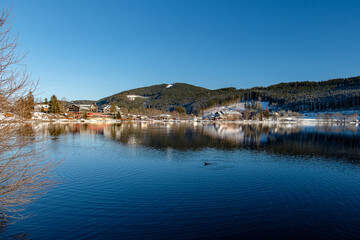 The Landscape by the lake during the winter time in Baden-Württemberg with snow and water reflection