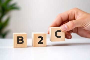 A hand holding a wooden block with the letter 'C', positioned next to 'B2' blocks, illustrating the concept of B2C (business-to-consumer) model in marketing and sales.
