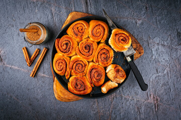 Homemade cinnamon snail rolls backed with brown sugar served as top view in a backing form