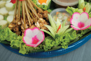 Satay is a popular  Indonesia dish of seasoned, skewered and grilled chicken and meat, served with peanut sauce.