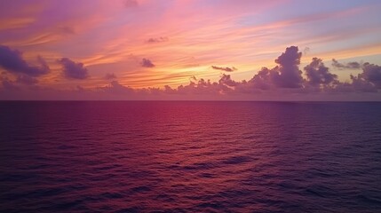 Vibrant sunset over calm ocean; purple, pink, orange hues.
