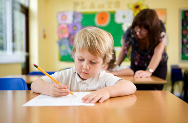 Elementary School: Problem Solving. A junior school pupil concentrating on his maths problem while...