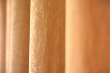 Softly draped golden curtains create a warm and inviting atmosphere, suggesting comfort, privacy, or theatrical anticipation