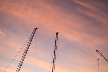 Fototapeta premium Silhouette of construction crane with beautiful sunset sky.