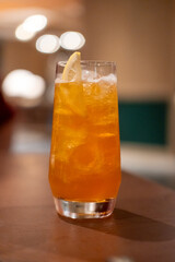 Close up view of orange cocktail on the table with bokeh background