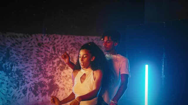 Multiethnic dancers moving slowly and tenderly in dance studio, romantic love. Sensual dance performance, African American man and his girlfriend touching each other and dancing, heterosexual pair