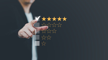 Hand touching and making a five-star yellow mark on a black background is customer satisfaction and...