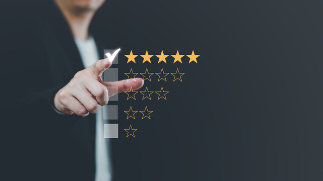 Hand touching and making a five-star yellow mark on a black background is customer satisfaction and the best evaluation for good quality products and services