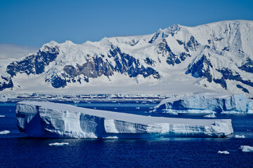Iceberg with snow covered mountains in Antarctica