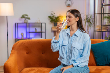 Thirsty woman hold glass of natural filtered aqua make sips drinking still water preventing...