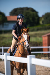 Woman riding a horse on the jumping race