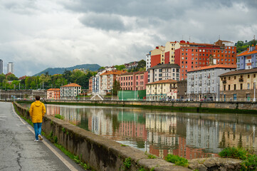 Man in a yellow jacket walking in Bilbao City