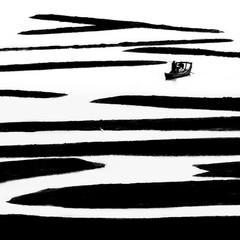 silhouette of a fishing boat among low tide at the mudflats