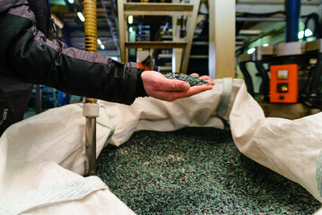 hands hold or touching biodegradable plastic pellets, plastic polymer granules