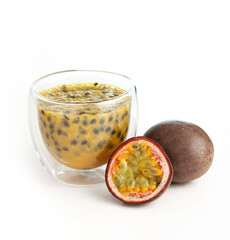 Fresh passion fruit with seeds in a glass cup and whole fruit on white background. Exotic tropical...